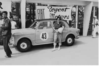 Macau, 1954: Maria Fernanda pousa em frente ao seu carro e placa do patrocinador, antes de competir na corrida feminina do Grand Prix Macau