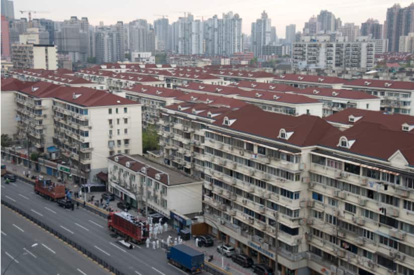 Workers in PPE unload groceries from a truck before distributing them to local residents under the COVID-19 lockdown in Shanghai.