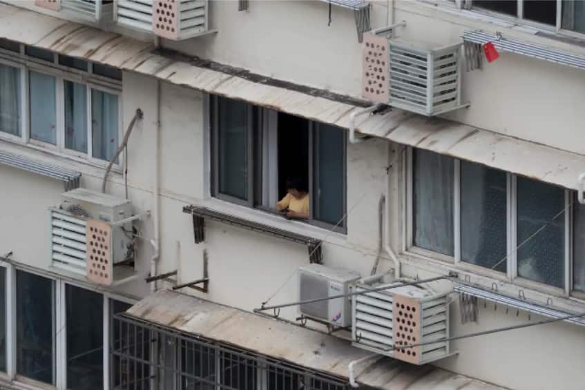A resident of a containment building looks out of a balcony in Shanghai, China.