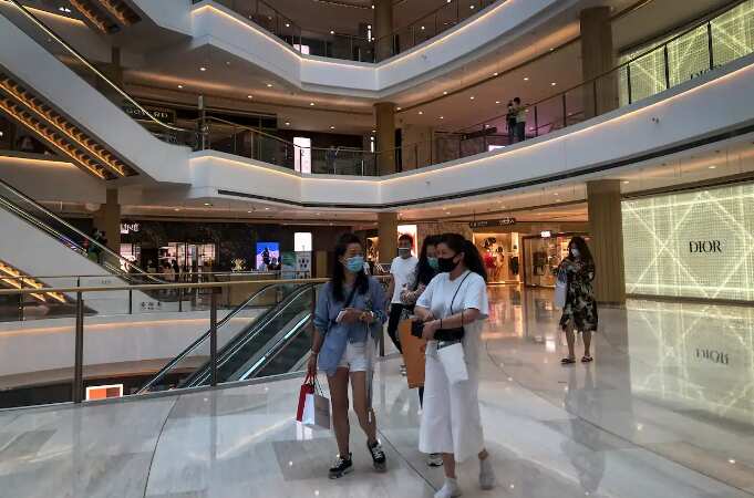 Shoppers wearing face masks walk through a reopened shopping mall in Shanghai, China on 29 May 2022. 