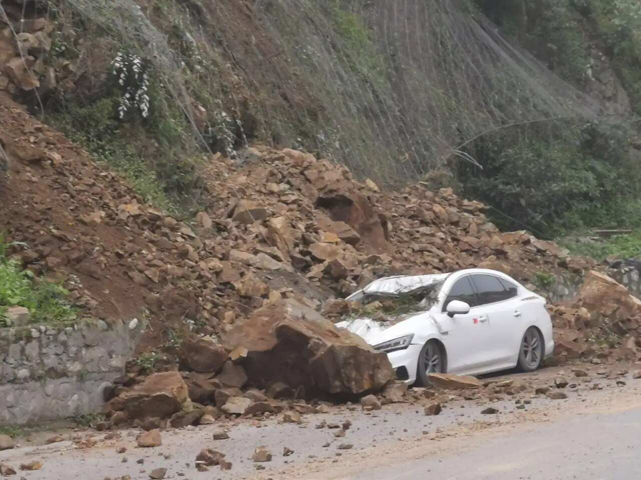 LUSHAN, CHINA - JUNE 01: A car is buried in landslide rubble following an earthquake on 1 June, 2022 in Lushan County, Ya an City, Sichuan Province of China. A 6.1-magnitude earthquake jolted Lushan county on Wednesday afternoon. 