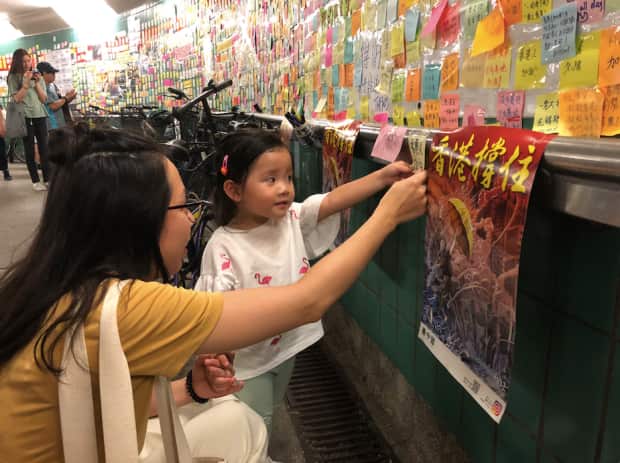 Cassie Chan with her daughter, who wrote words of encouragement for Hong Kong on a Post-it.