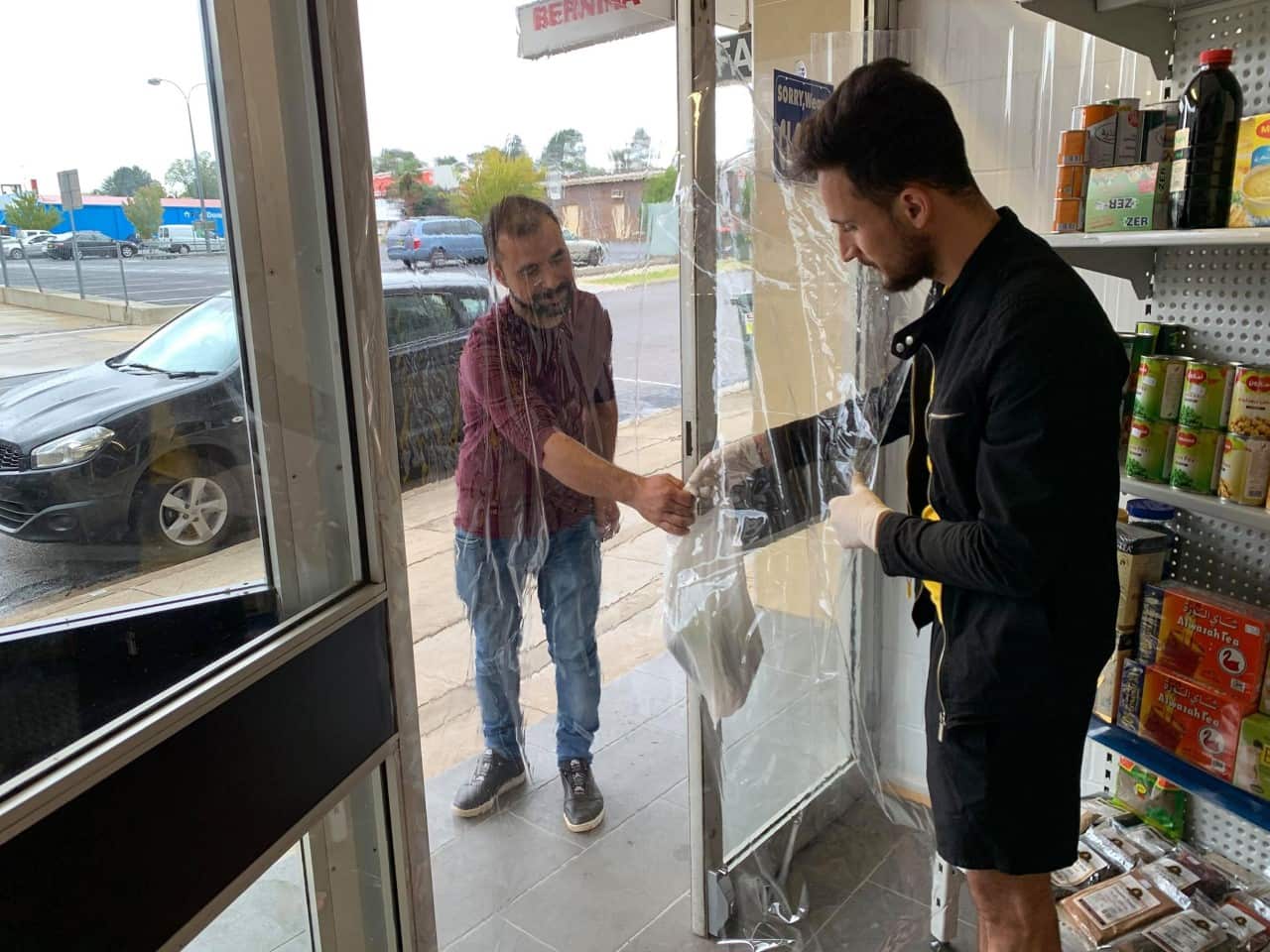 A worker handing goods through to a customer. 