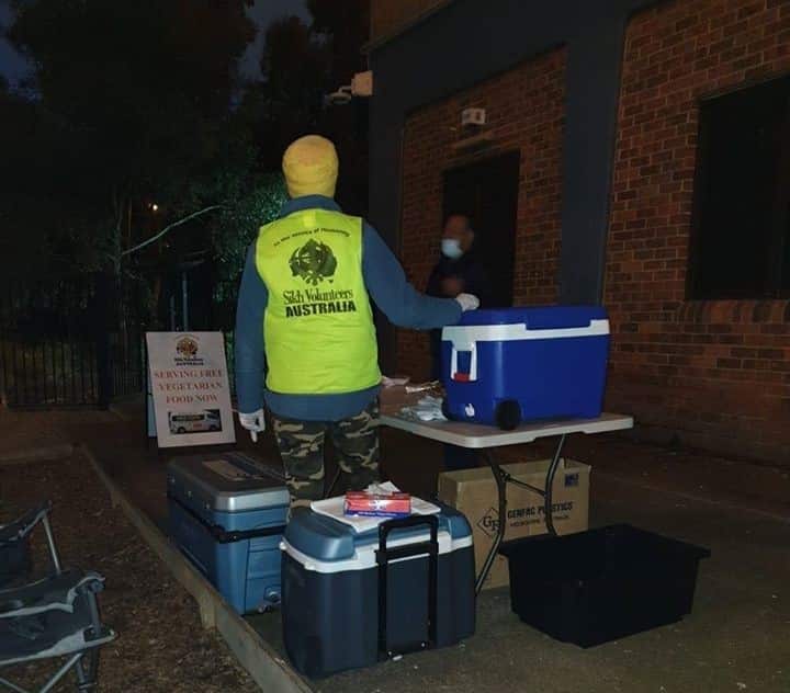 A Sikh volunteer serving free meals at a public housing estate near Flemington on Sunday night. 