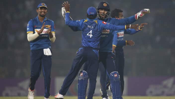 Sri Lanka's Dinesh Chandimal, second right, celebrate with his teammates the dismissal of Bangladesh's Tamim Iqbal during the second and final Twenty20 international cricket match in Sylhet, Bangladesh, Sunday, Feb. 18, 2018. (AP Photo/A.M. Ahad)
