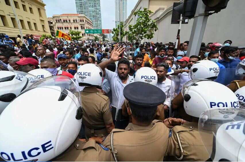 Government supporters and police confront each other outside Sri Lanka's president's office in Colombo, on 9 May, 2022.