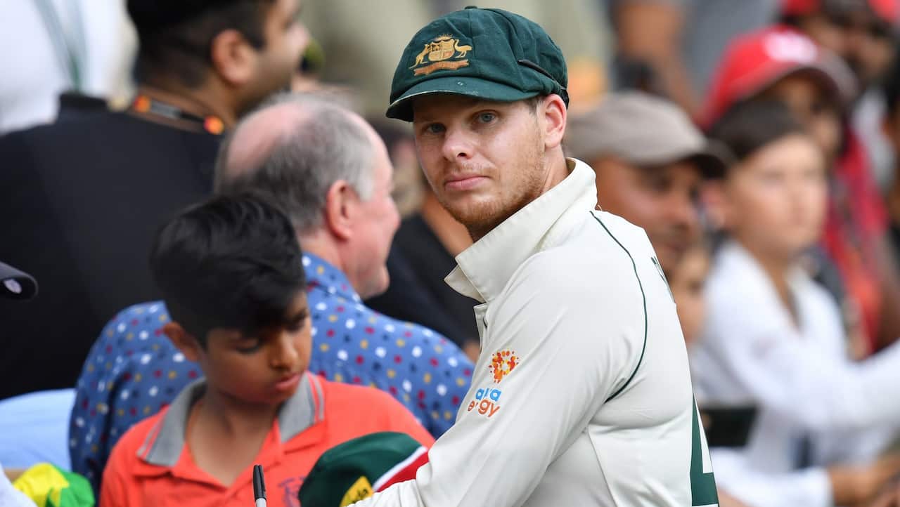 Steve Smith of Australia is seen signing autographs for fans.