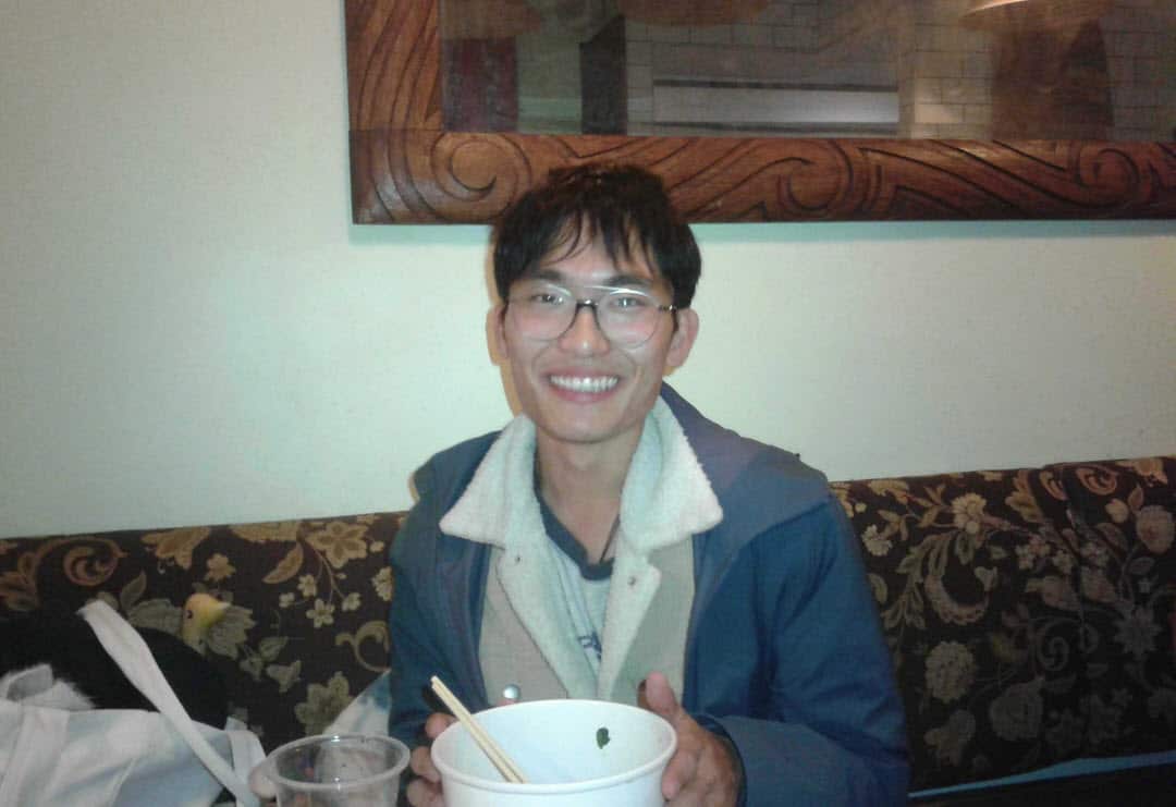 Qi Zhang sitting on a couch