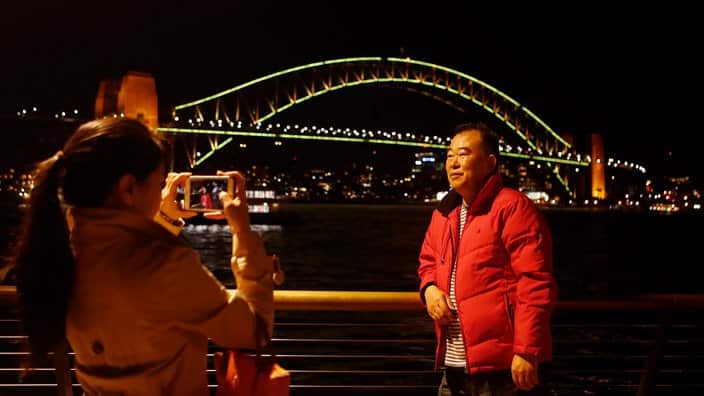 Tourists take pictures in front of the The Sydney Harbour Bridge.