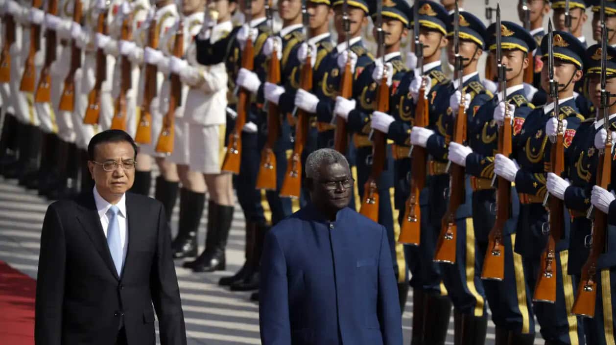 نخستوزیر چین لی کِچیانگ (چپ) در کنار نخستوزیر جزایر سلیمان مناسه سوگواره در حال رد شدن از جلو گارد افتخاری در تالار بزرگ مردم پکن، ۹ اکتبر ۲۰۱۹.