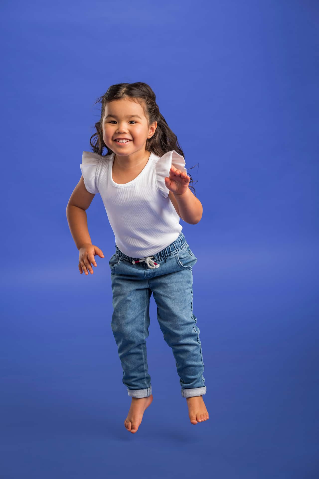 Sora, a four year old girl who was born with Leber's congenital amaurosi, jumps for the photoshoot for Jeans and Genes.