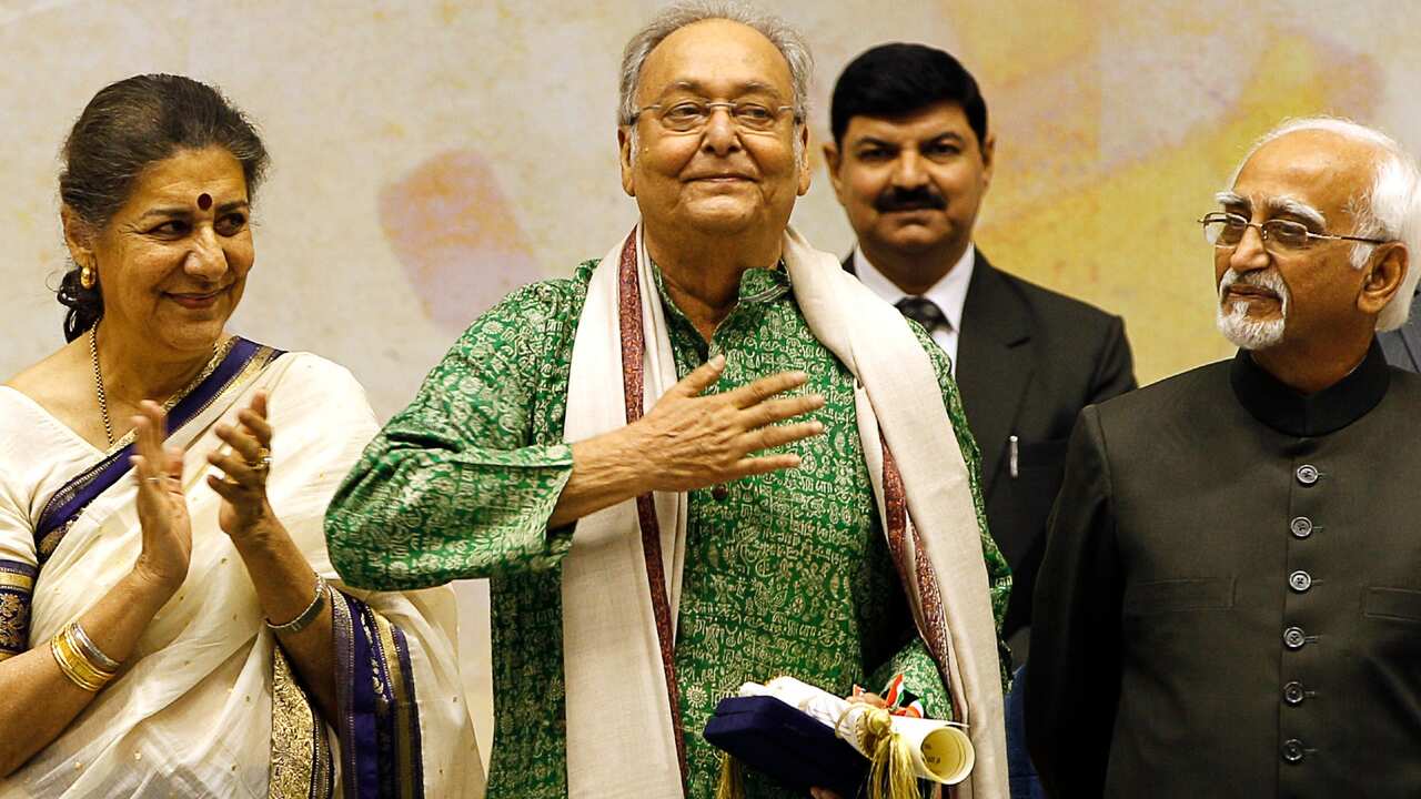 In this May 3, 2012 file photo, Bengali language film actor Soumitra Chatterjee, center, gestures after receiving the Dadasahab Phalke Award for the year 2011