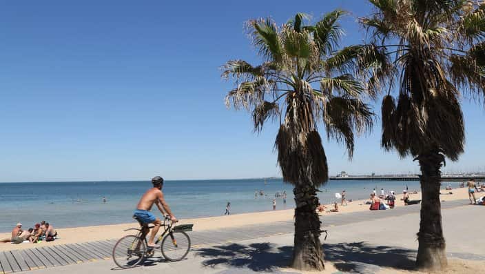 A man rides his bike at St Kilda beach during hot weather in Melbourne, Friday, January 19, 2018.