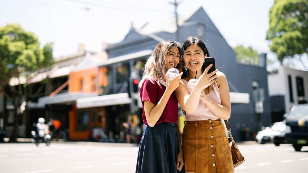 Two girls enjoying a day walk and milkshakes – Getty Images/visualspace