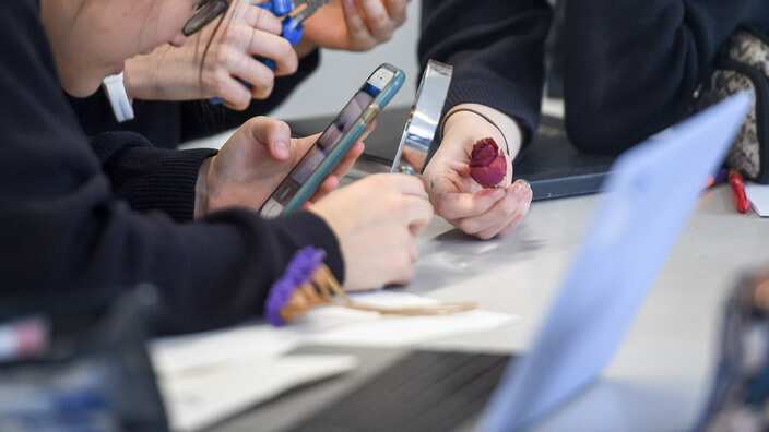 Students use a mobile phone in an art class. 