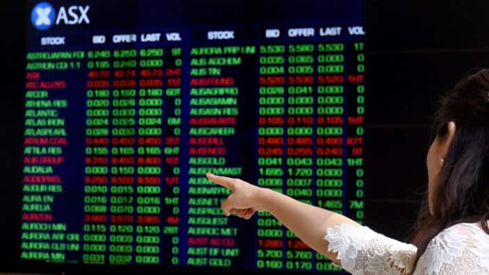 A tourist points at the Australian Stock Exchange (ASX) indicator board in Sydney on Friday, April 1, 2016. (AAP Image/Mick Tsikas) NO ARCHIVING