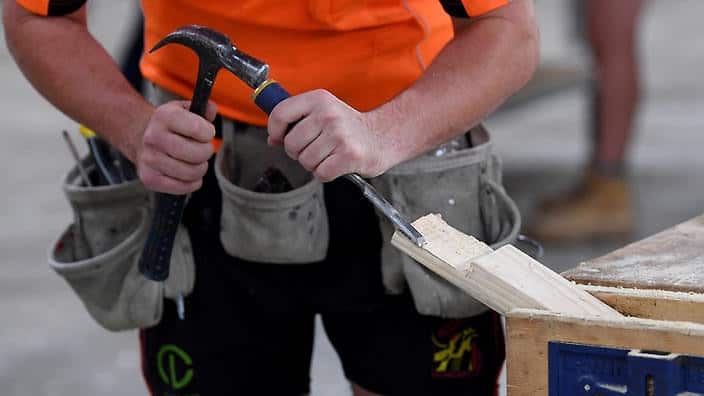 A man doing wood work during a course in construction.