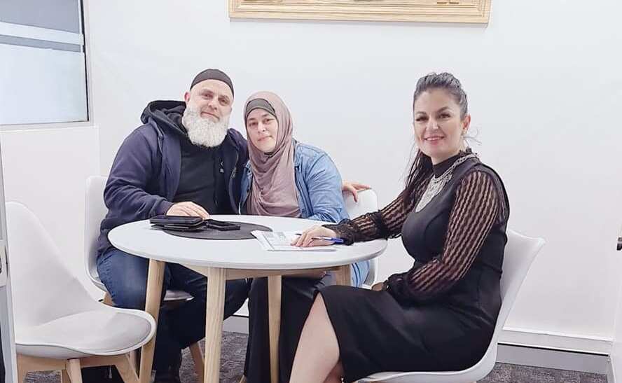 Sydney-based Afghan tax expert Tahera Jehanbeen sitting with clients at her accountant firm. 