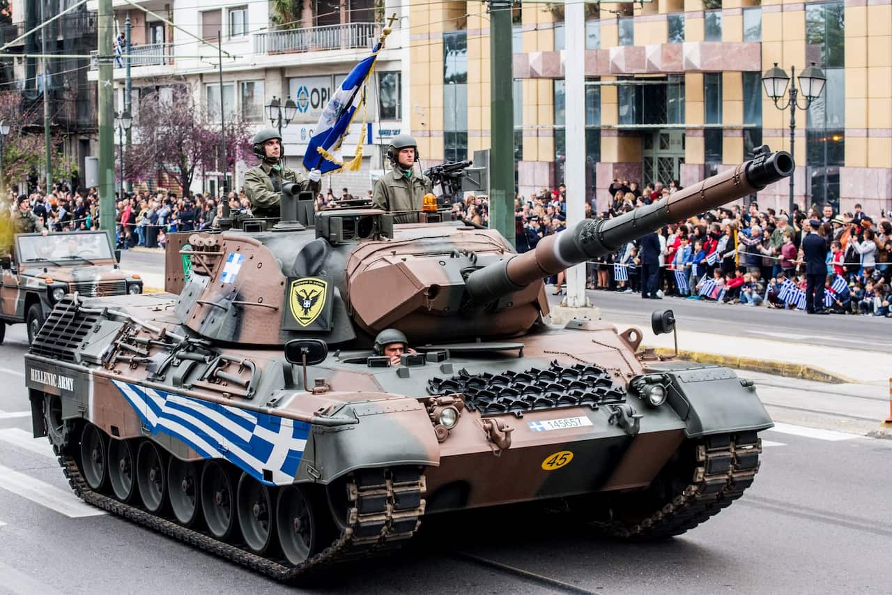 A tank passes in front of the crowd during the parade. A