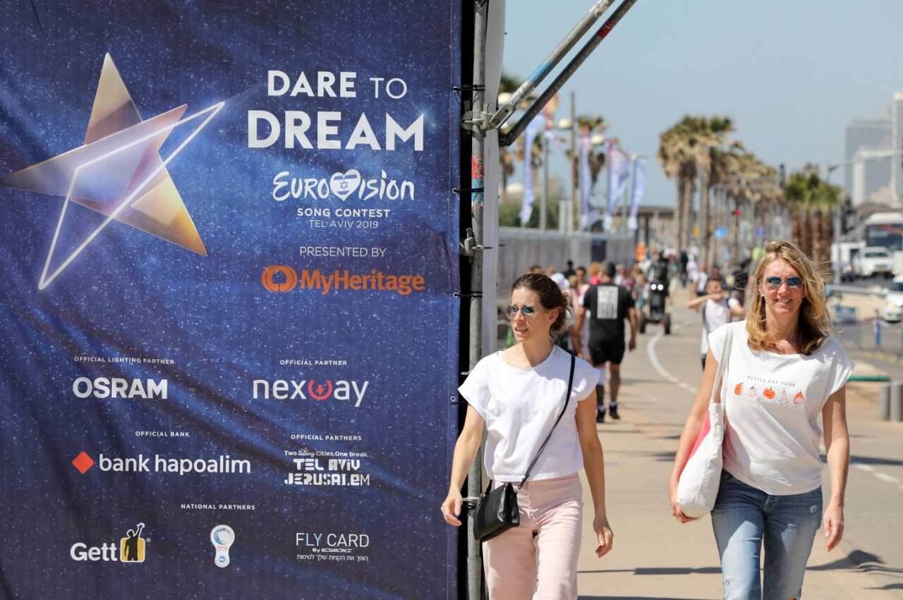 Tourists walk by an Eurovision banner near the Eurovision Village in Tel Aviv, Israel, 12 May 2019. Between 10,000 and 20,000 tourists will make the journey.