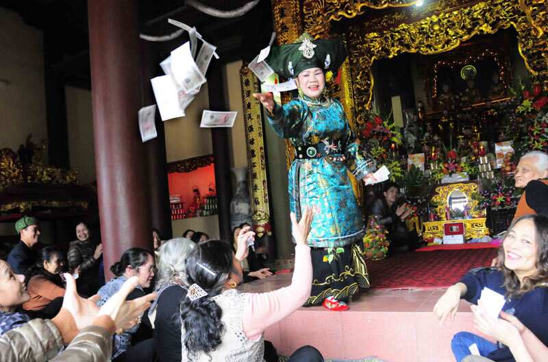 Bà đồng ném tiền cho người theo đồng