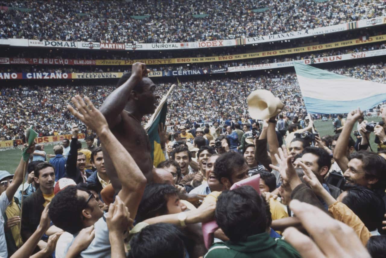 Pelé is held up on the shoulders of fans and Brazil national football team officials as they celebrate Brazil's 4-1 victory over Italy 