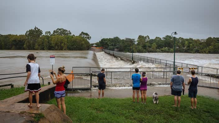 Locals observe floodwaters at Black Weir in Townsville, Friday, February 1, 2019. Townsville residents are again being told to leave their homes as north Queensland's flood disaster rolls on. (AAP Image/Andrew Rankin) NO ARCHIVING