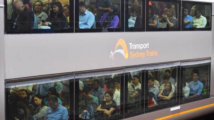 People sit in a Sydney Trains carriage during rush hour.