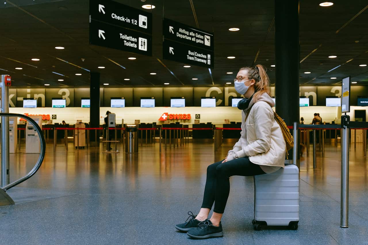 Woman sitting on luggage at airport
