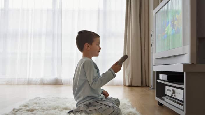 Boy sitting on floor watching cartoons in television