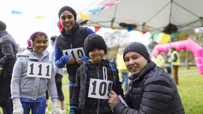A smiling family preparing for charity run in park