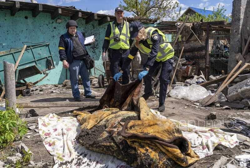 Ukrainian police inspect the body of a man reportedly killed in the recent shelling of the city of Kharkiv by Russian forces following its exhumation, Kharkiv, Ukraine, 16 May 2022.