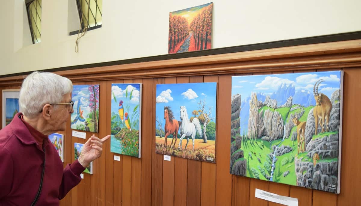 An elderly woman watching Naser's works