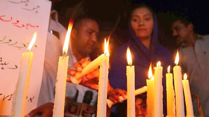 People light candles as they condemn the deadly bomb blasts in Sri Lanka, during a protest in Karachi, Pakistan.