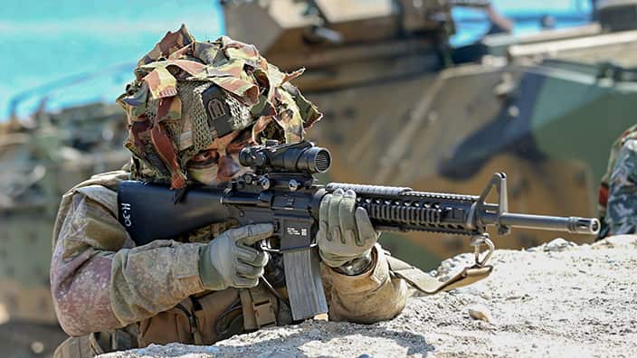 Army soldier aims at drill. 