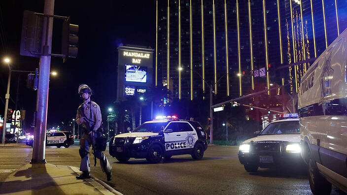 Police officers stand along the Las Vegas Strip outside the Mandalay Bay resort and casino during a deadly shooting near the casino.