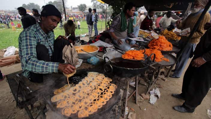 An Indian vendor prepares Jalebi sweet for customers.