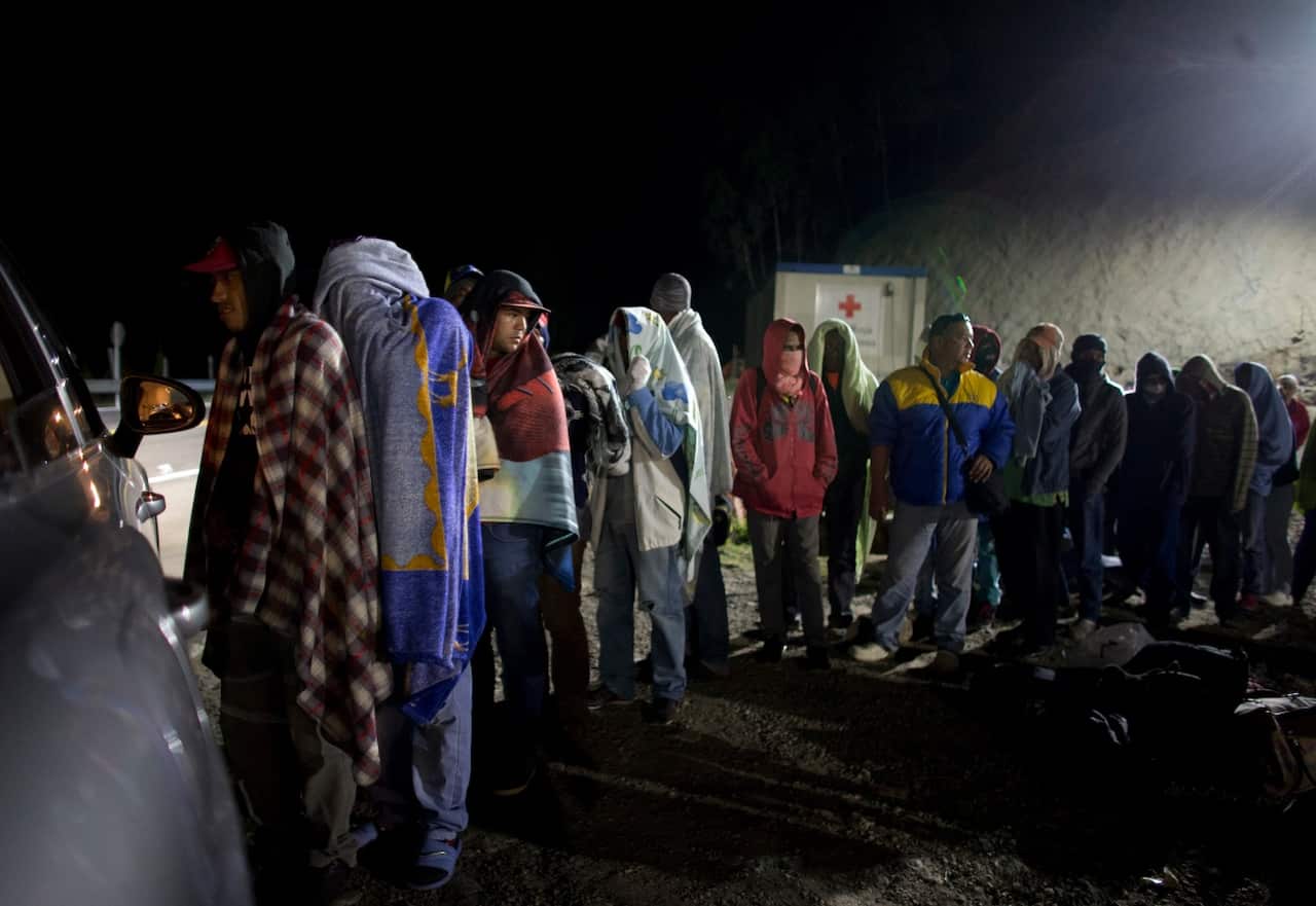 In this Aug. 31, 2018 photo, Venezuelan migrants line up for free bread and coffee,