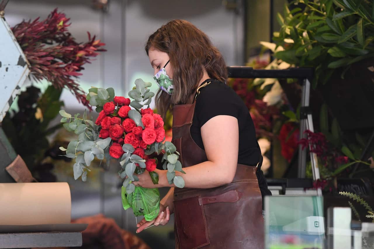A florist works on an order inside the Flowers by The Road Stall in Melbourne, Saturday, February 13, 2021.