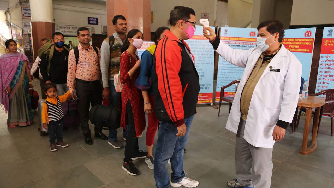 An Indian doctor checks the temperature of passengers at a railway station as a precautionary measure against the coronavirus in Jammu, India.