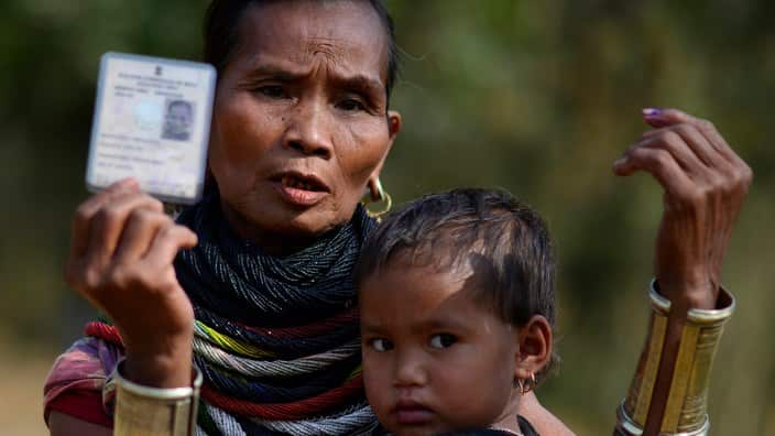 A tribal women shows her voter card.