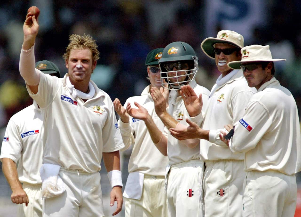 Australia's Shane Warne, left, displays the ball after taking his 537th wicket against India in 2004.