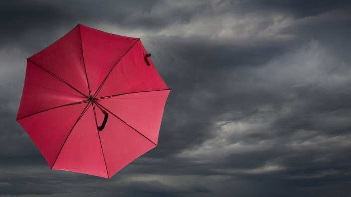 Red umbrella blowing in storm