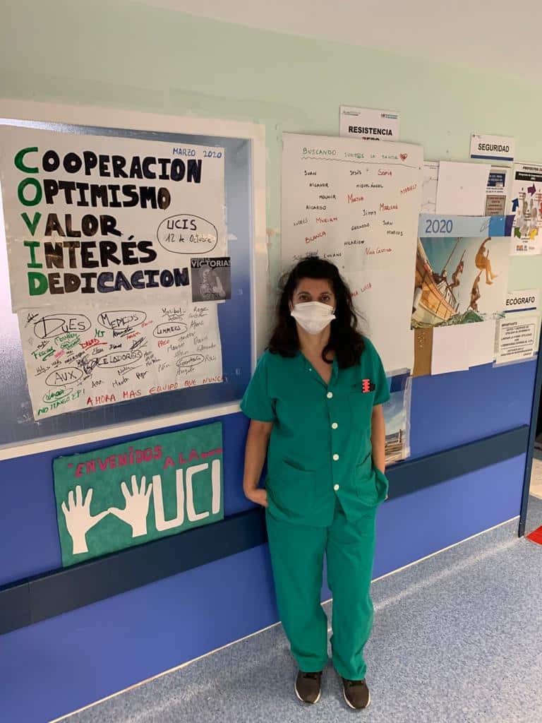 Maribel in front of the staff bulletin board in ICU.