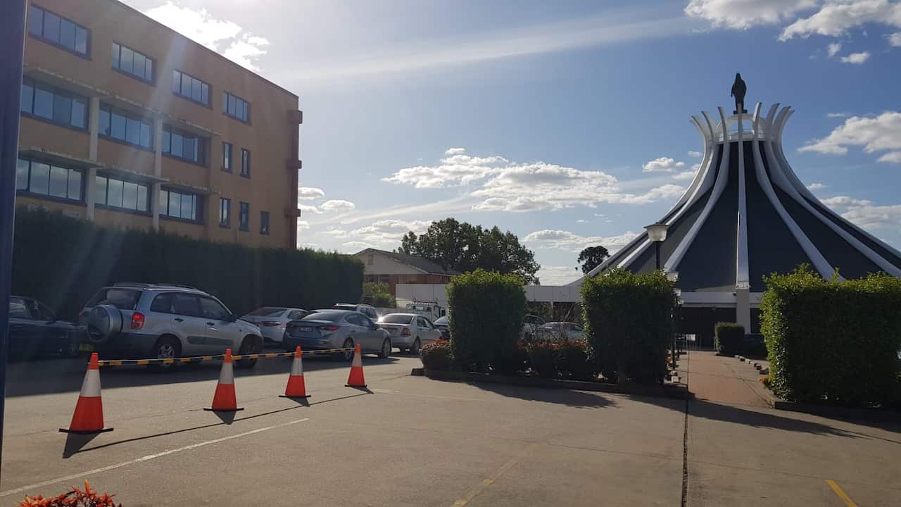 Cars wait for Corona pop up test in Lady of Lebanon Church in Sydney.