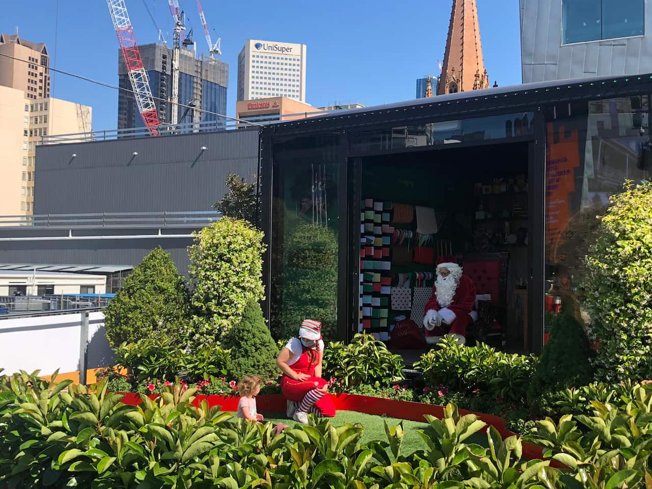 A child visits Santa at Federation Square, while keeping the social distance for Coronavirus