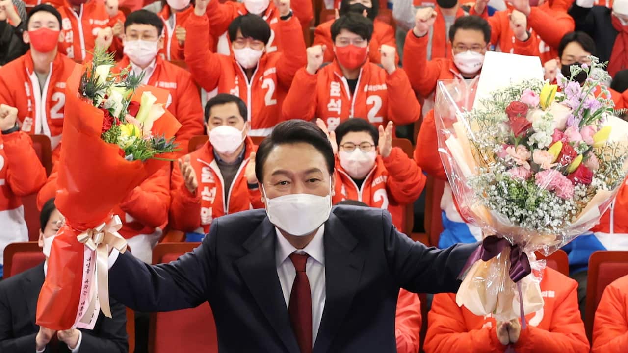 Yoon Suk-yeol of the main opposition People Power Party poses with bouquets after he was elected President 