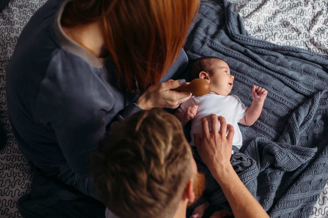 Young parents giving of attention to their baby.