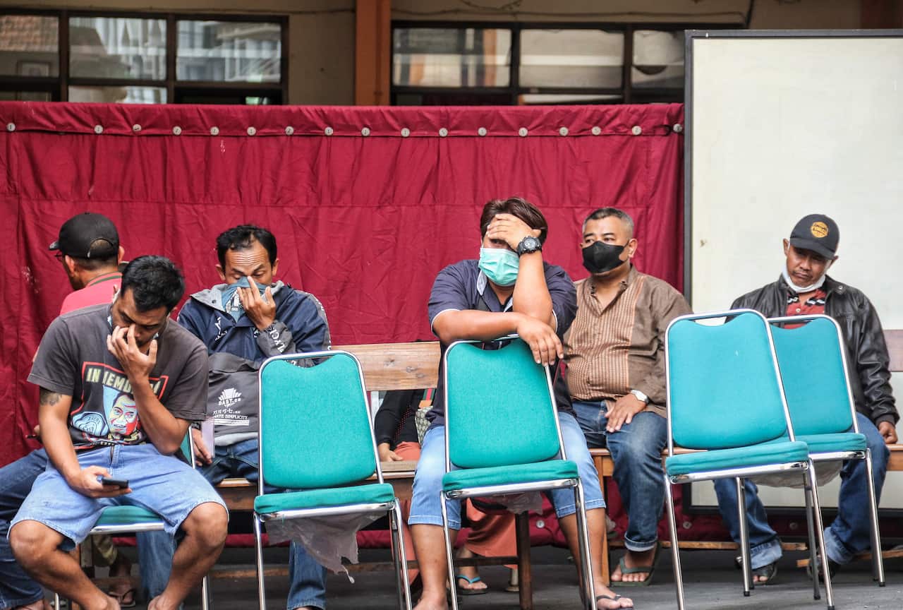 Relatives are pictured waiting for confirmation on whether their missing relatives are among those killed in a soccer match stampede at a hospital in Malang, East Java. 
