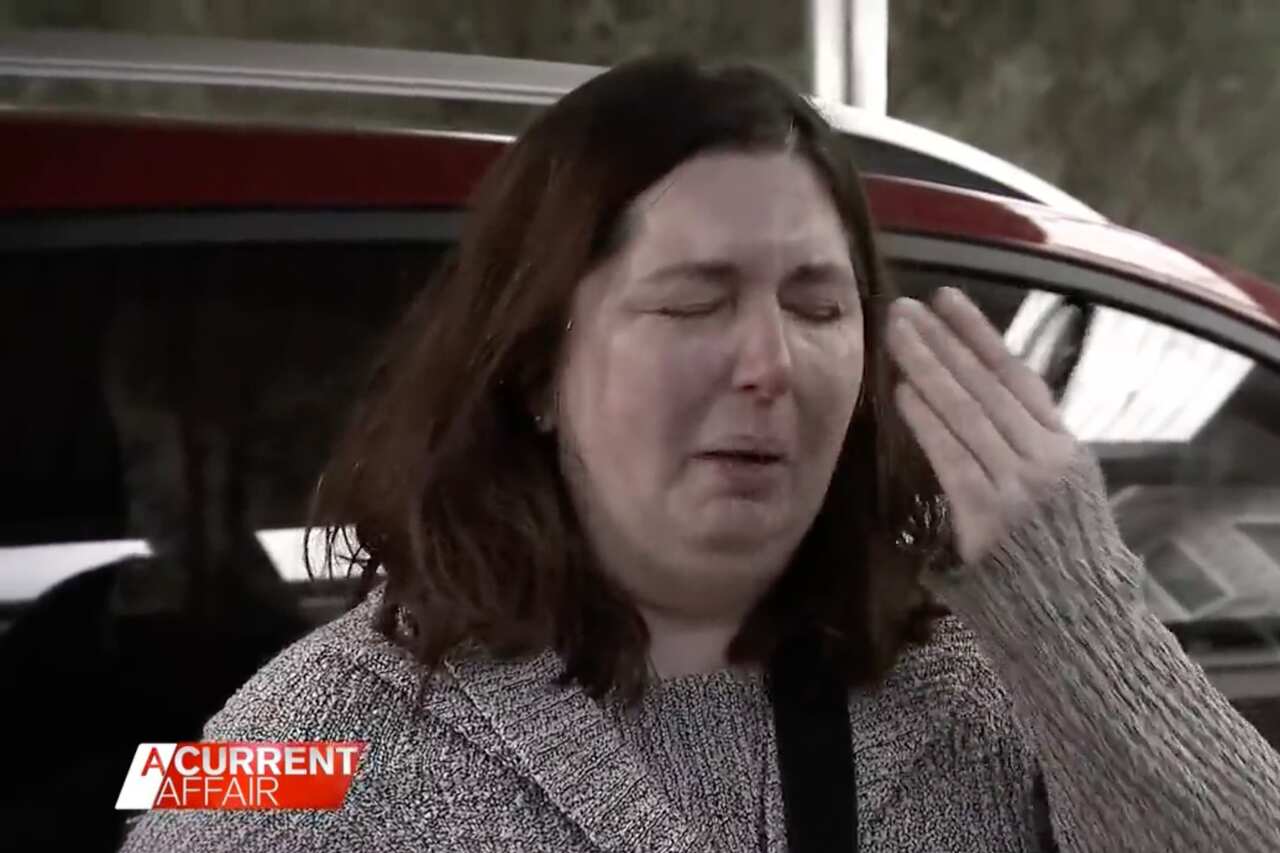 A woman cries as she speaks to reporters